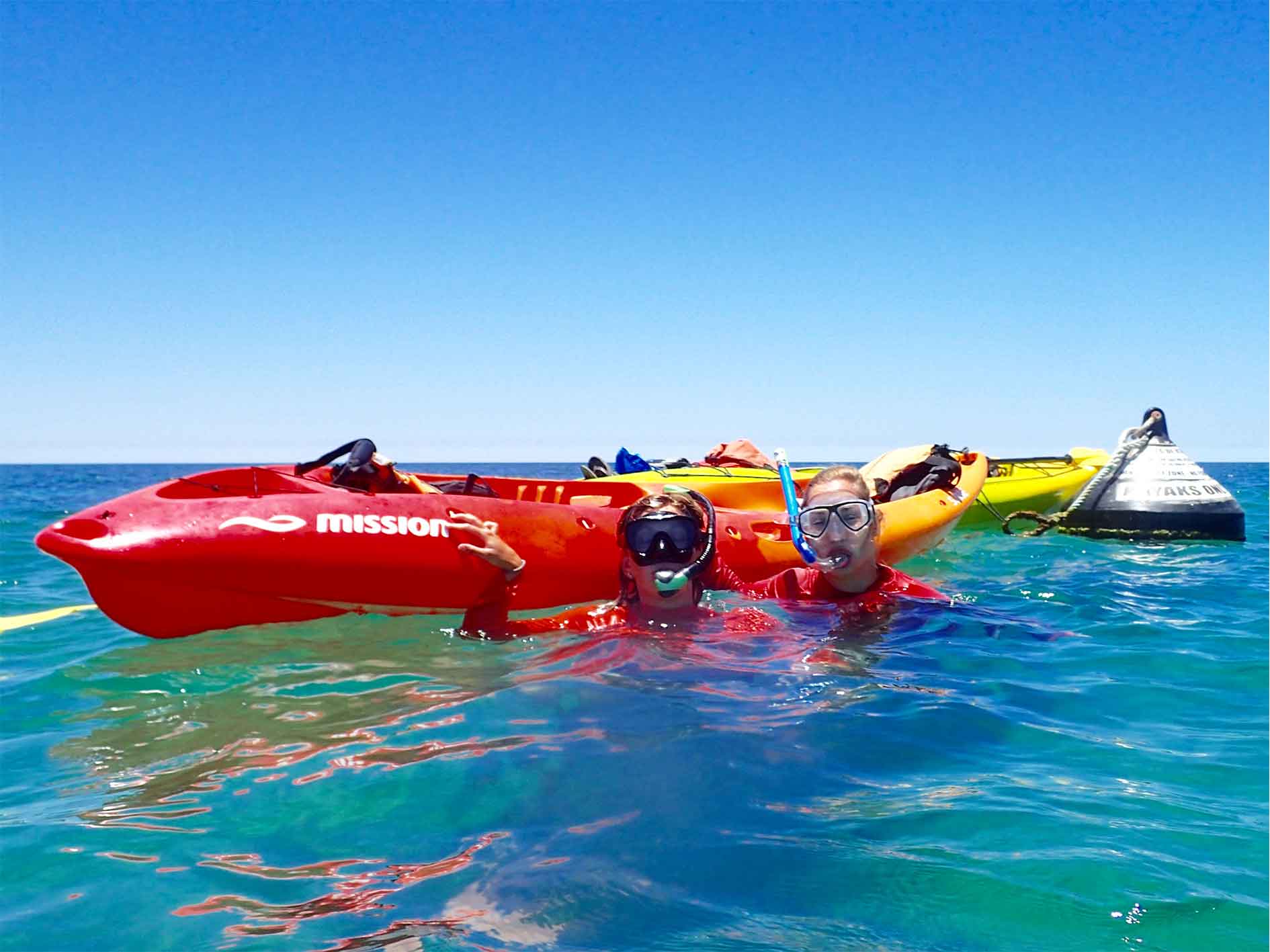 Couple wearing hire snorkel equipment in water with hire kayak at Ningaloo Reef, Exmouth, Western Australia