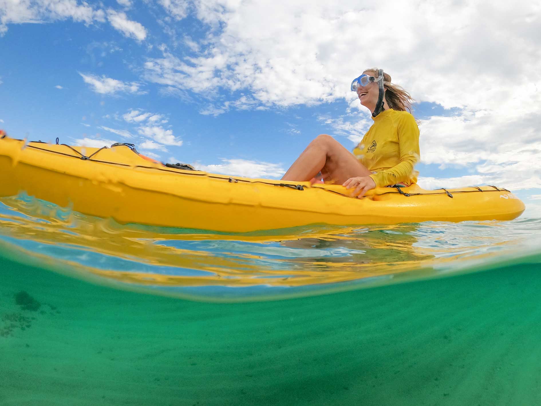 Lady sitting in a kayak with snorkel mask on during Coral by Kayak tour