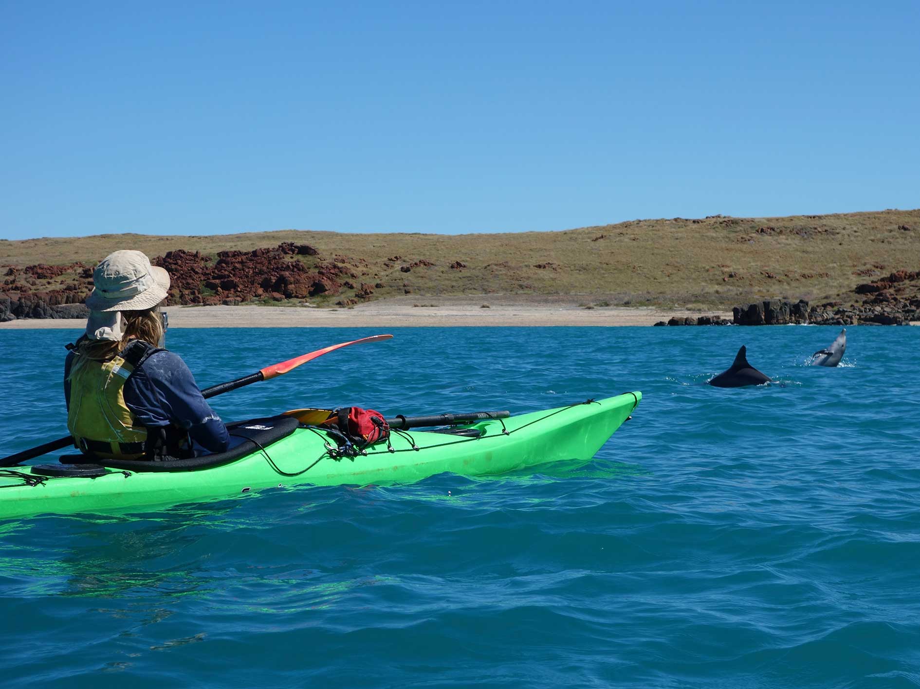 Sea kayaking along a rocky cliff, Dampier Archipelago